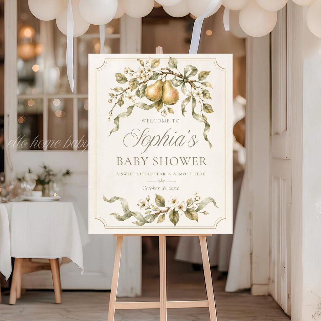 Pear baby shower welcome sign beneath white balloons at an elegant gender-neutral shower entrance.