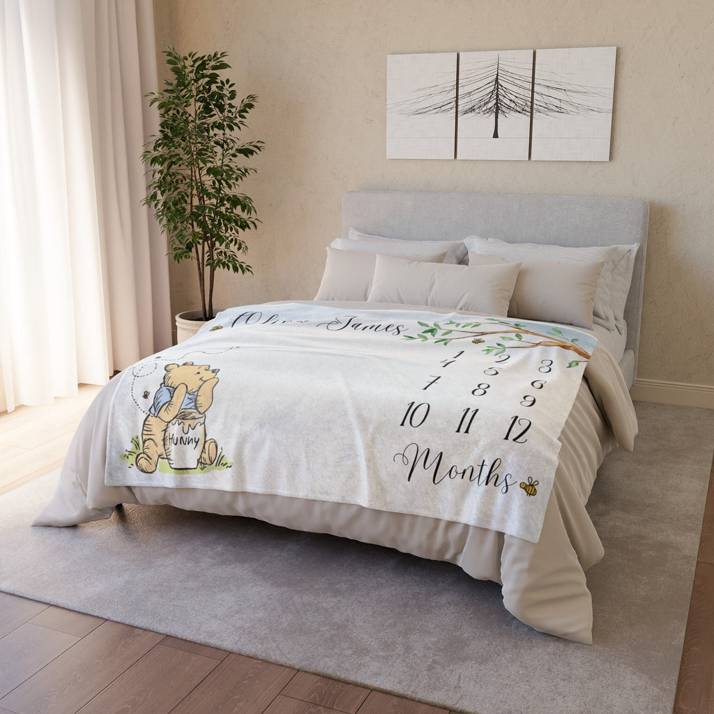 Blue baby month blanket with Storybook Winnie the Bear and a honey pot. The blanket has a tree with leaves and numbers 1-12 for each month. The text "Oliver James" and "Months" are printed on the blanket. Minky Fleece 60x50 inches.