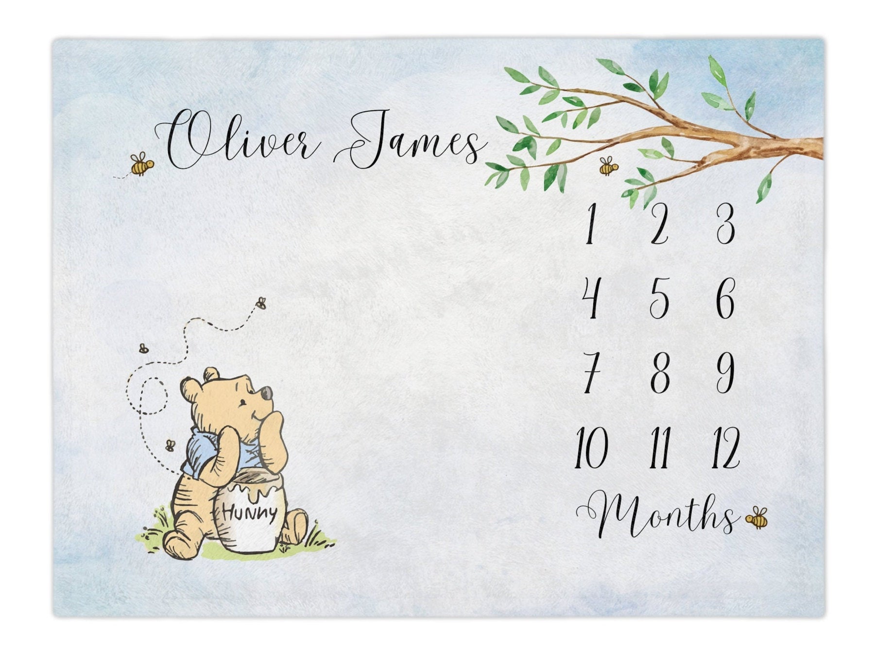 Classic Storybook Bear baby milestone blanket. Classic Winnie the bear inspired monthly growth blanket. The winnie bear has a blue shirt. The blue watercolor hue, bumble bees make this an adorable baby shower gift for baby boy. baby month blanket. Calendar monthly Growth blanket.