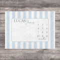 Blue Heirloom Stripe Baby Milestone Blanket. Baby Milestone Blanket Boy, Personalized Month Blanket Blue Striped, Preppy Monthly Growth Mat, Custom Baby Shower Gift. A rectangular milestone blanket with a light blue and white striped border. The center features a light blue frame with the name "LUCAS James" and numbers 1-12 with the word "months" below.