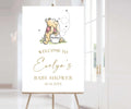 May include: A Winnie the Pooh themed baby shower welcome sign with a cartoon illustration of Winnie the Pooh holding a honey pot. The sign says "Welcome to Evelyn's Baby Shower 10.14.20XX".