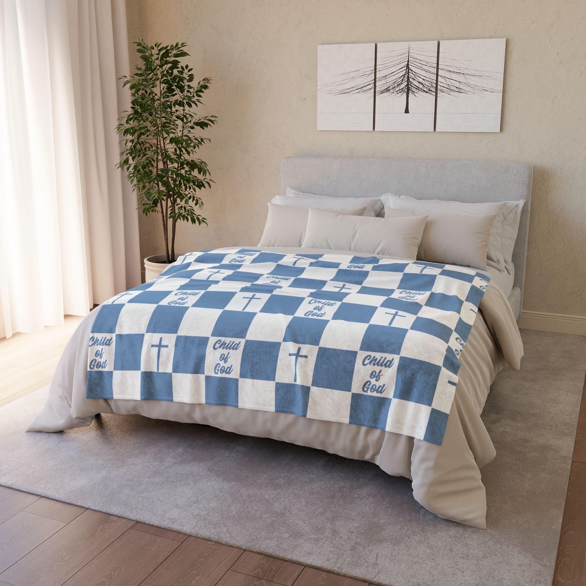 Blue Christian baby blanket styled in a cozy natural bedroom, featuring a repeating blue gingham pattern with crosses and Child of God typography. ELLO HOME BABY