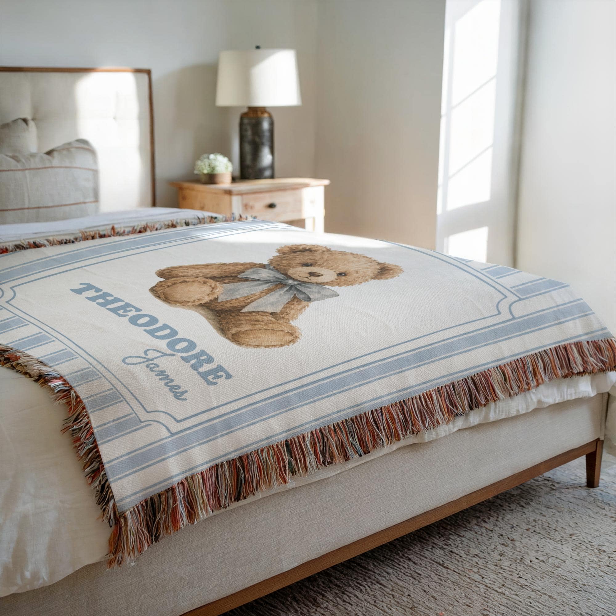 Heirloom Woven Teddy Bear Blanket with blue stripes laid flat on a neutral bed.