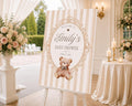 Personalized vintage teddy bear baby shower welcome sign with neutral brown and beige stripes, heirloom scroll frame, and watercolor teddy bear displayed on a wooden easel.