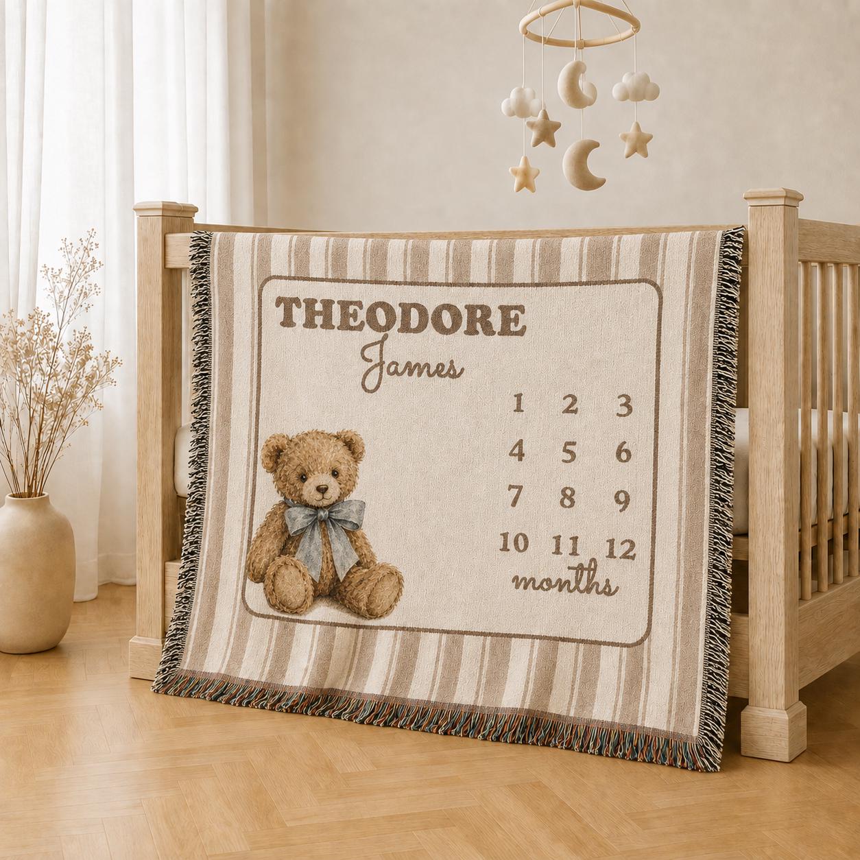 Personalized teddy bear milestone blanket hanging over a light wood crib in a warm neutral baby nursery.
