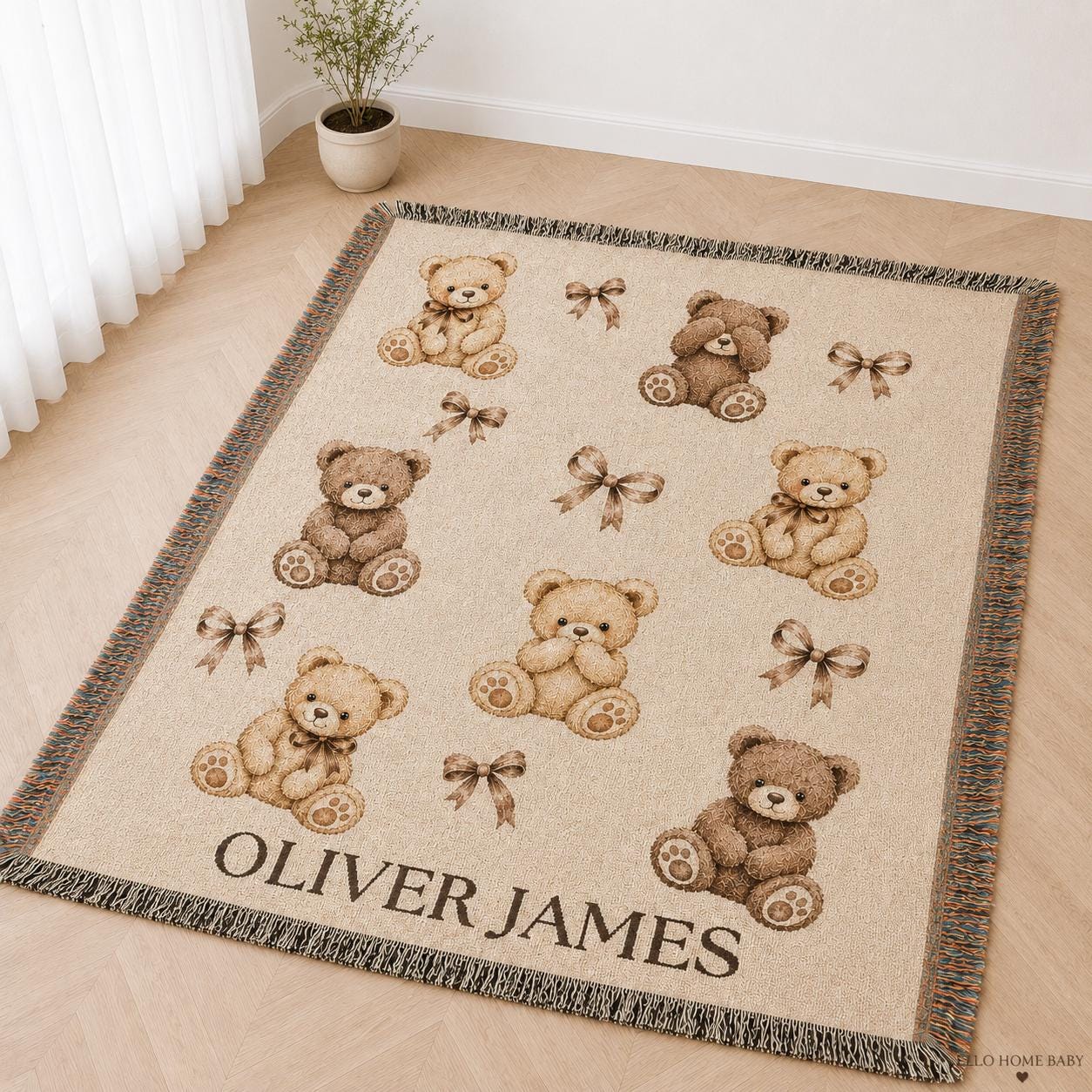 Custom baby name woven blanket in a neutral teddy bear pattern, shown at an angle on a light nursery floor with visible cotton threads and fringe.